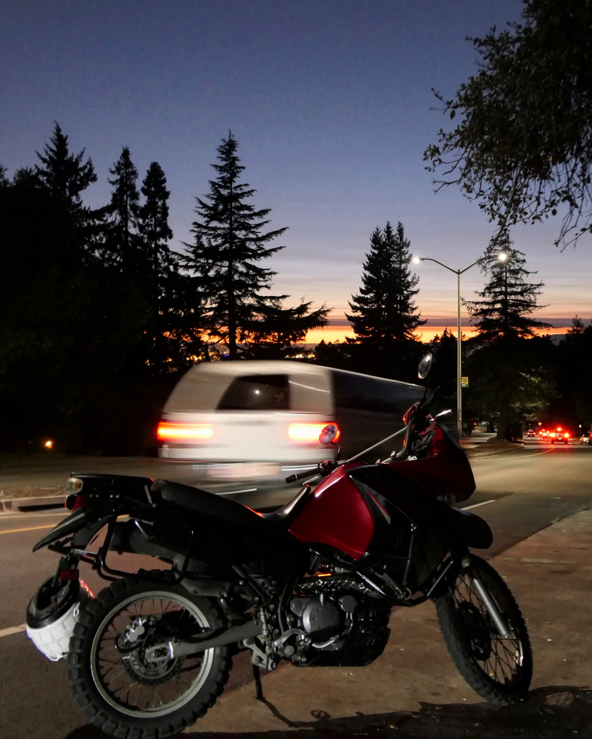 A moody photo of my 2010 Kawasaki KLR 650 in the dark with blurry trails of car headlights behind it